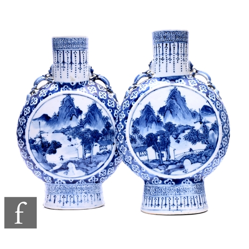 483 - A pair of 19th Century Chinese blue and white moonflasks, each rising from a high footring, extendin... 