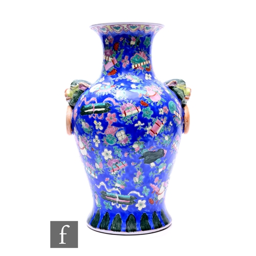 522 - A 20th Century Chinese baluster vase, flanked by mask ring handles, the blue ground picked out in po... 