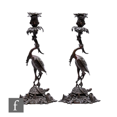 529 - A pair of Japanese Meiji period (1868-1912) candlesticks, modelled as cranes standing on tortoises a... 