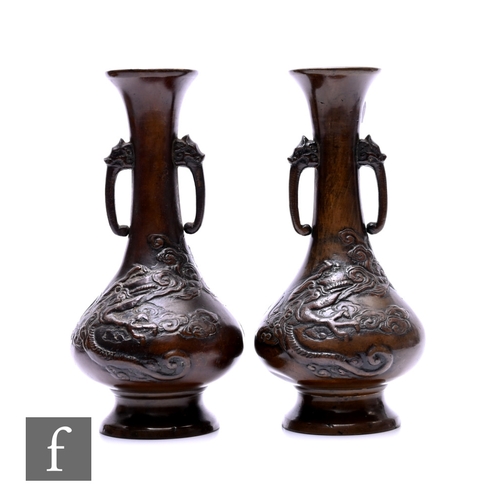 536 - A pair of Japanese late Meiji Period (1868-1912) bronze vases, each of bottle form, with relief cast... 