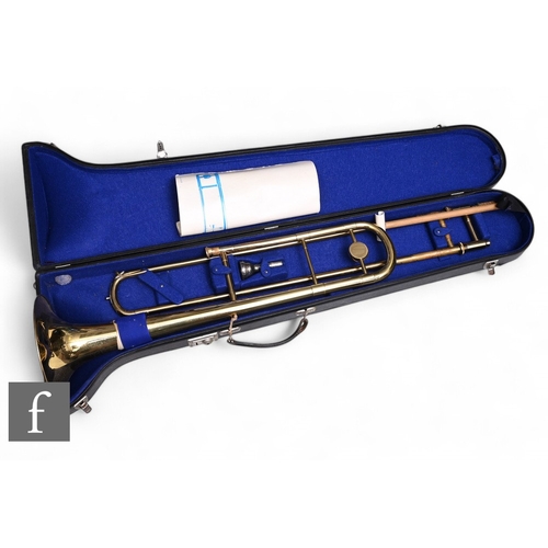 122 - A brass trombone in fitted plush lined case with instruction, length 94cm.