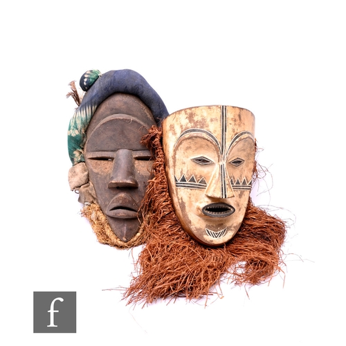 578 - An African Dan carved wood mask from the Ivory Coast, with fabric decoration and straw beard, togeth... 