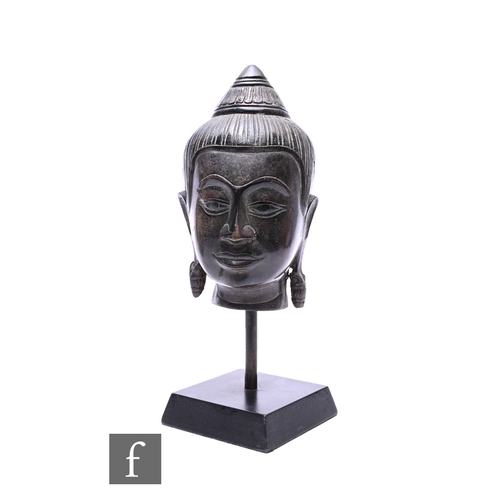 542 - A Chinese/Tibetan cast metal figure of a Buddha head, with serene expression with downcast eyes, hig... 