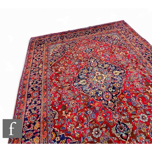 568 - A large Persian Tabriz style carpet, with central rectangular shaped section with red and blue panel... 