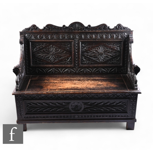 1039 - A Victorian carved dark oak settle, the panel back united by down swept arms terminating serpent end... 