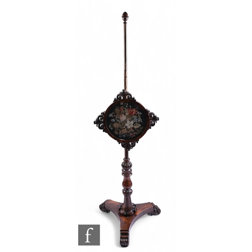 1042 - A 19th Century rosewood pole screen with circular floral tapestry panel and pierced scroll mounts on... 