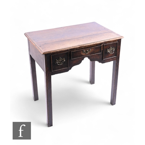 1043 - A small George III oak lowboy, fitted with three drawers below a moulded edge top on square block le... 