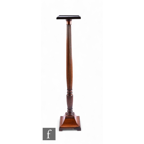 1052 - An Edwardian mahogany torchere, the square top over a reeded column on waisted square base, height 1... 