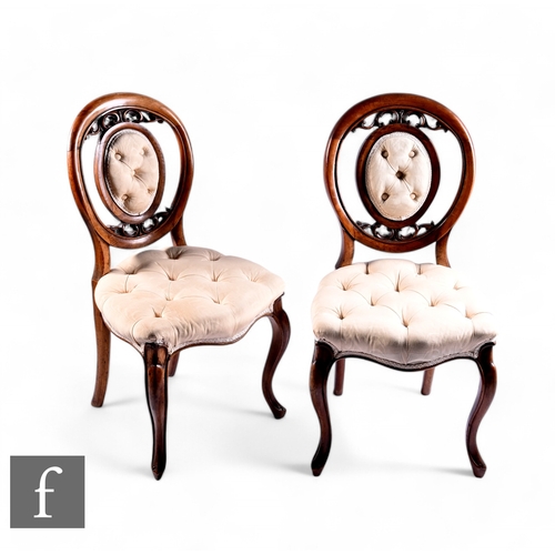 1060 - A set of four Victorian walnut salon chairs, pierced oval scroll backs on cabriole legs to the front... 