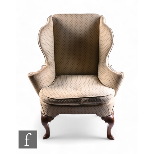 1070 - A George III style wing back and scroll open arm chair on cabriole legs terminating in hoof feet, up... 