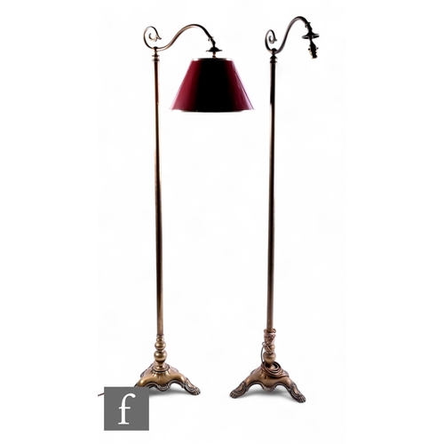 1091 - A pair of brass standard lamps, each with a scroll branch arm and shade on scroll tricorn base and p... 