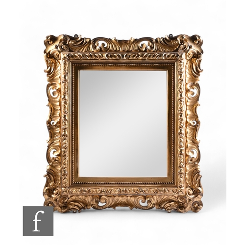 1057 - A large early 19th Century or earlier gilt framed wall mirror, deep 'C' scroll and scalloped frame w... 