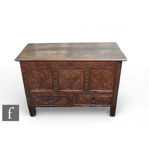 1058 - An early 19th Century and later carved oak mule chest, the moulded edge hinged top over a triple pan... 