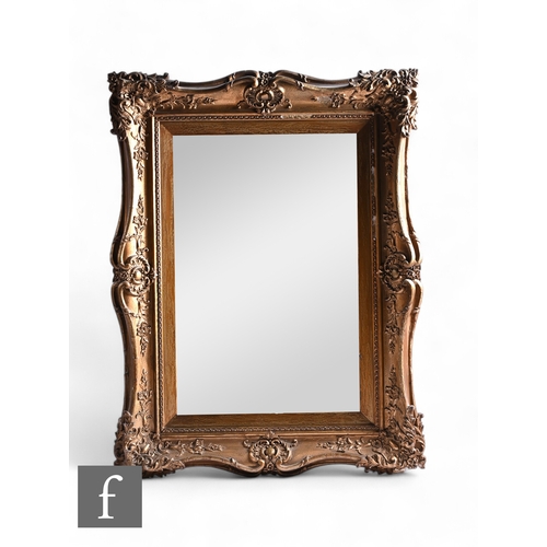 1072 - A Victorian gilt framed wall mirror, applied leaf and scroll border, 86cm x 67cm.