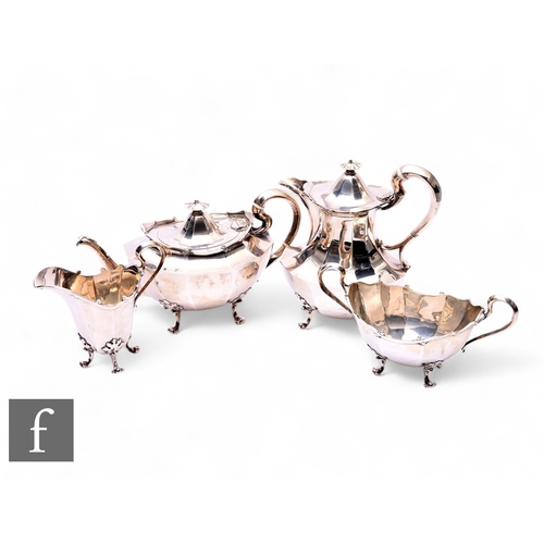 384 - A hallmarked silver four piece tea set of facetted form and each raised on four scroll legs, total w... 