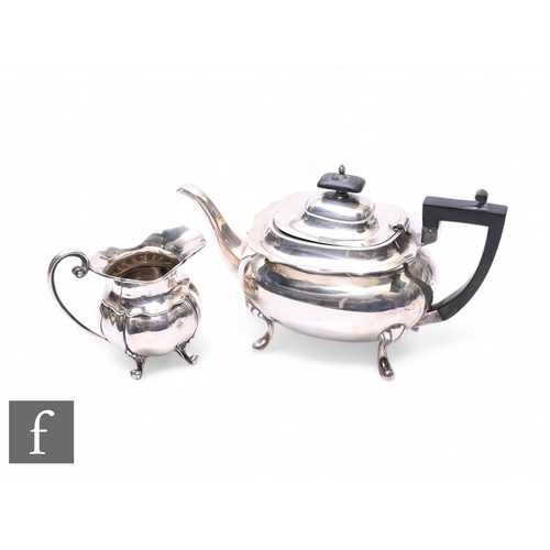 370 - A hallmarked silver boat shaped tea pot raised on four pad feet, with a similar cream jug, total wei... 