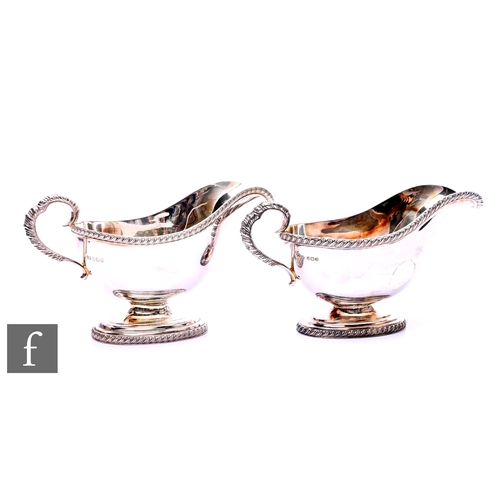 448 - A pair of 20th Century silver sauce boats, on oval pedestal bases with gadroon borders and scroll ha... 