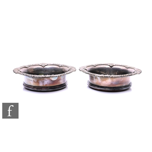 449 - A pair of 20th Century silver bottle coasters in the Georgian style, with shell patterned and gadroo... 