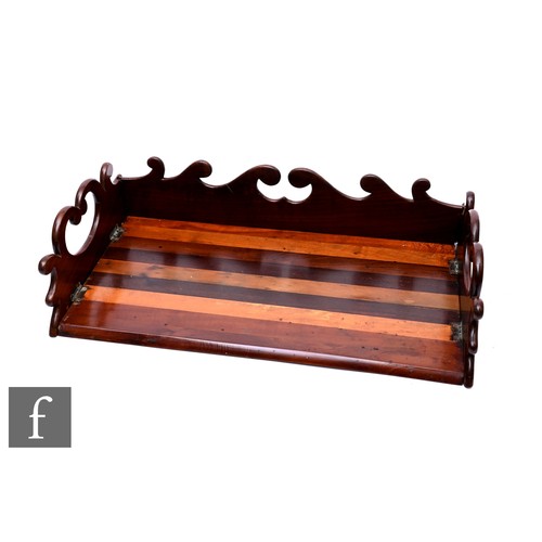 779 - A 19th century mahogany and exotic wood book tidy, scroll shaped sides over chamfered front, the bas... 