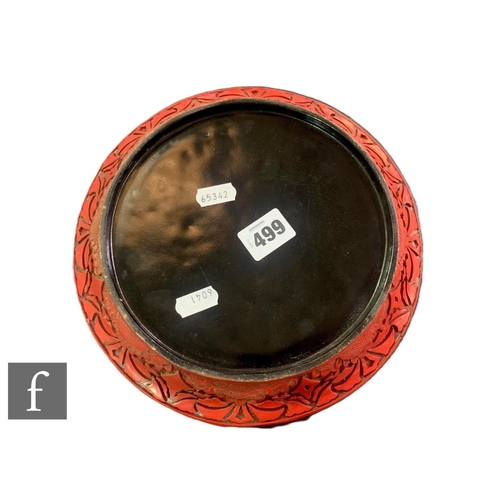 499 - A Chinese 20th Century cinnabar lacquer dish, carved with orchids before a scroll ground, diameter 2... 