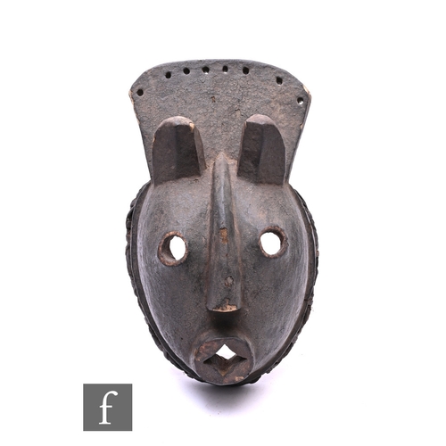 570 - An African Ogoni Karikpo ceremonial mask from Nigeria, of carved wood with protruding features, leng... 