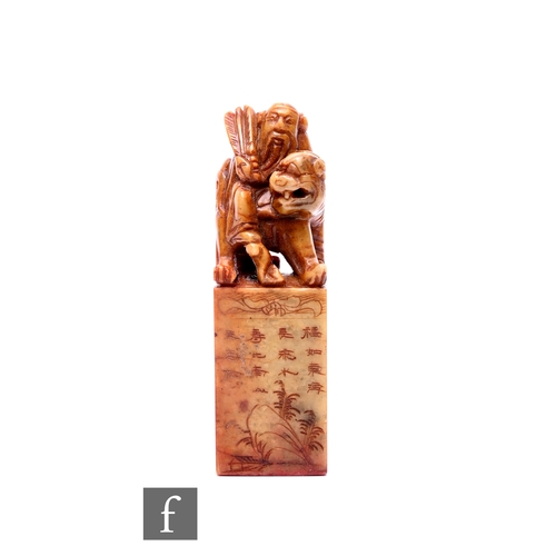 524 - A mid 20th Chinese soapstone desk seal of block form mounted with a sage and a dog of Fo, cased, hei... 