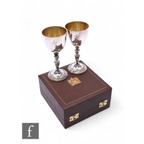 495 - A cased pair of hallmarked silver commemorative goblets for the Silver Wedding Anniversary of Queen ... 