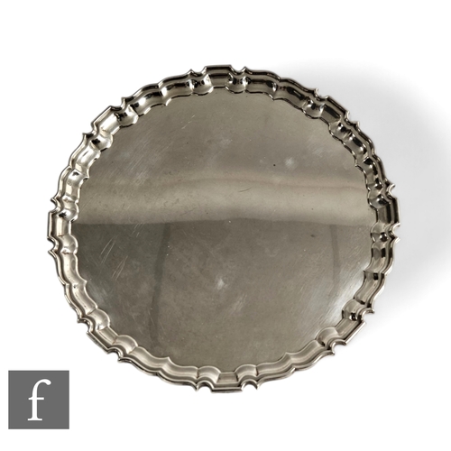 517 - A later 20th Century silver salver in the Georgian style, with scalloped border and raised to four l... 