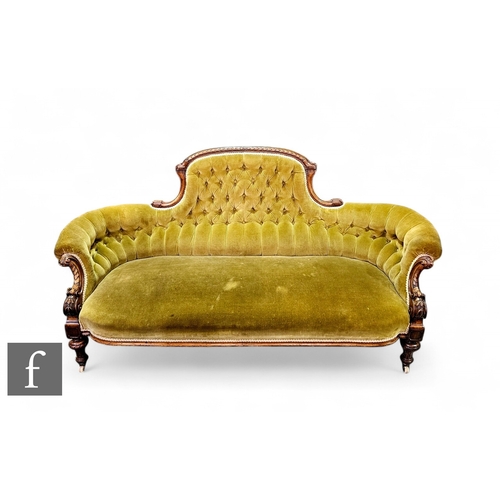 823 - A Victorian carved walnut three seater sofa shaped back flanked by scroll arms on turned block legs ... 