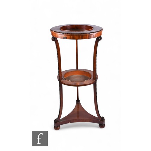 833 - A William IV mahogany two tier jardiniere stand of circular form with toleware liners, the upper tie... 