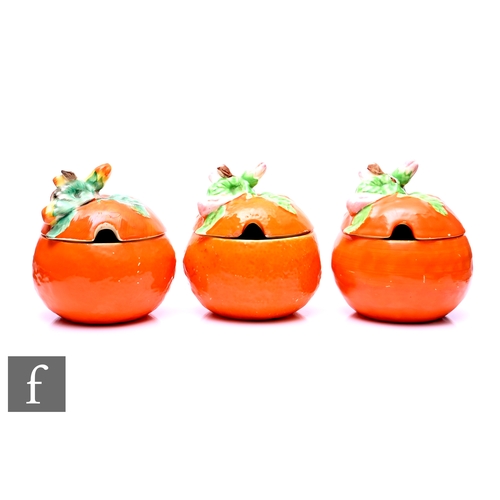 56 - Three Clarice Cliff preserve pots and covers each in the shape of an orange, circa 1930, hand painte... 