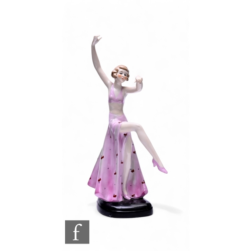 58 - A German Art Deco figure of a dancing lady, in pink vest top and long flowing skirt, modelled with a... 