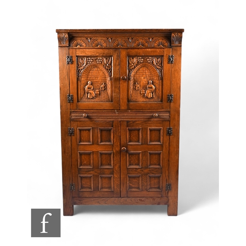 856 - A 1930s or later oak cocktail cabinet, fitted interior enclosed by a pair of arch carved doors detai... 