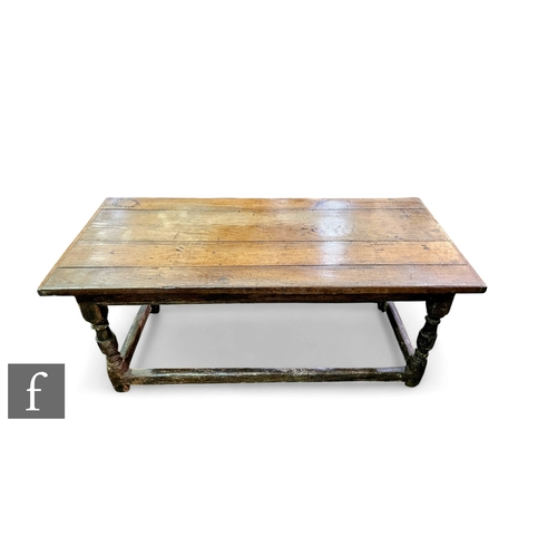 869 - An early 17th Century and later oak farmhouse table, the later rectangular four-plank top above turn... 