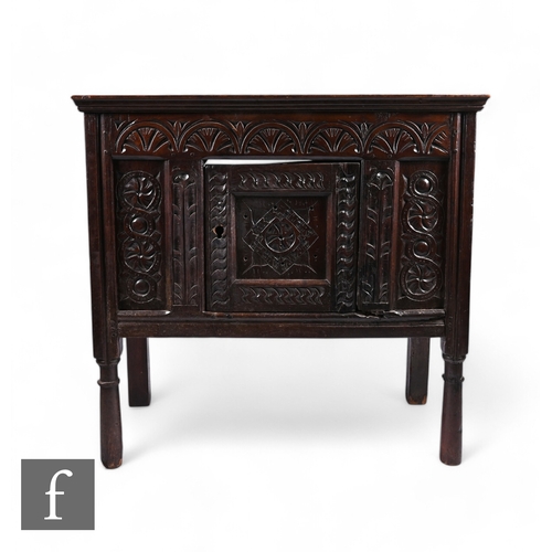 870 - A 17th Century and later oak hutch cupboard, with lunette frieze and conforming rosette carved panel... 