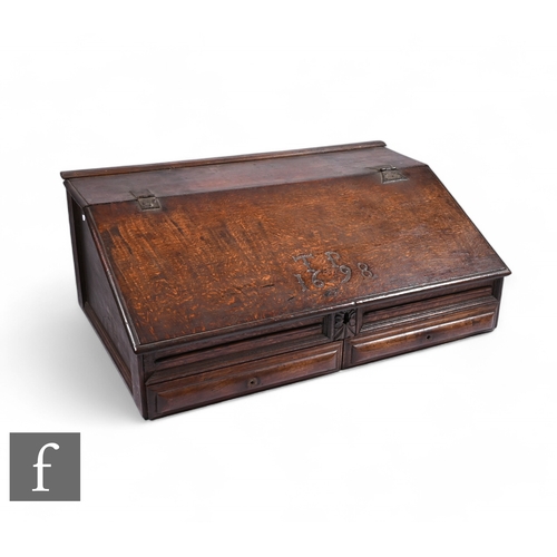 871 - A late 18th Century oak slope top bible box, the hinged lid enclosing four small internal drawers ab... 