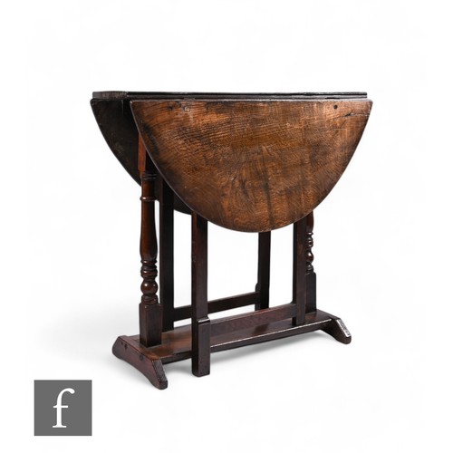 862 - A late 17th Century and later constructed oak oval gateleg table, with turned supports over a slab b... 