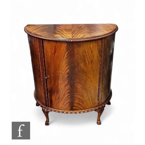 875 - A Chippendale style mahogany demi lune side cabinet on claw and ball feet below a gadrooned edge, he... 