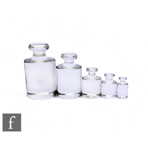 455 - A set of five glass weights ranging from 1kg to 5oz, of cylindrical form, with flattened knop finial... 