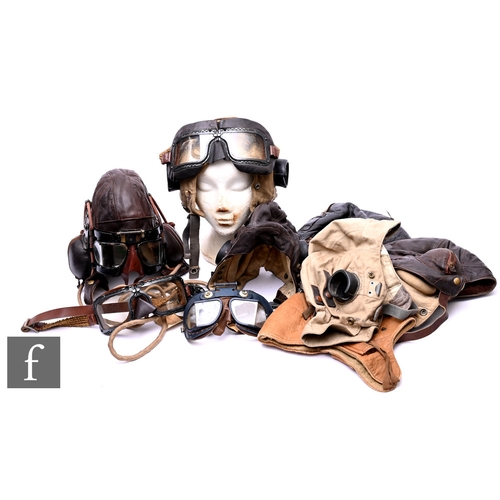 624 - A collection of German and British brown and black leather World War Two flying helmets, some labell... 