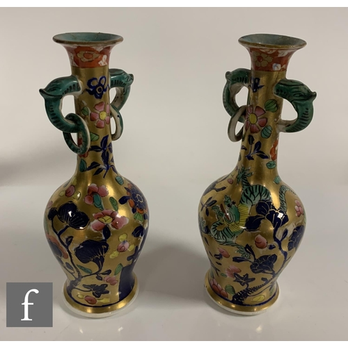 89 - A pair of Miles Mason vases, of inverse baluster form with high drawn neck, twin mask loop and ring ... 