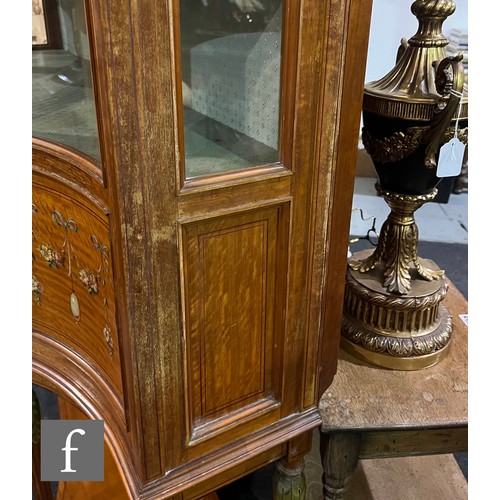 785 - An Edwardian serpentine painted satinwood display cabinet, enclosed by a glazed door, below moulded ... 