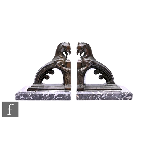 542 - A pair of 20th century Art Deco bronzed book ends modelled as stylish griffins on black veined marbl... 