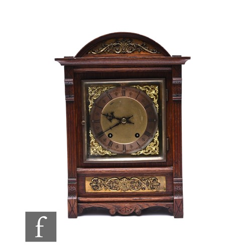 744 - An early 20th Century oak cased mantle clock, the eight day striking movement on a gong, silvered ch... 