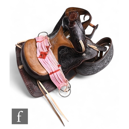 567 - A 20th Century Western tooled leather saddle, padded seat and horn, fenders and stirrups, width 60cm... 