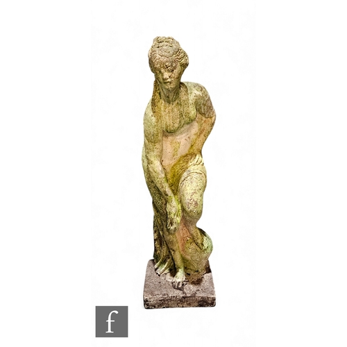 931 - A 20th Century composite stone figure of a semi naked classical Romanesque female with left leg rais... 