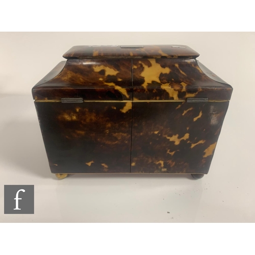 512 - A 19th Century tortoiseshell tea caddy, the caddy shaped top over a two divisioned interior, on bras... 