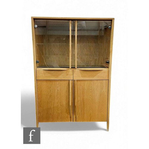 1286 - Ercol Furniture - A contemporary light oak bookcase cabinet, with glazed double doors over a conform... 