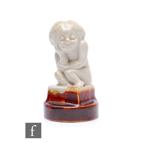 67 - Royal Doulton - A cast slipware figure, circa 1910, modelled as an impish 'hunched figure' on block ... 