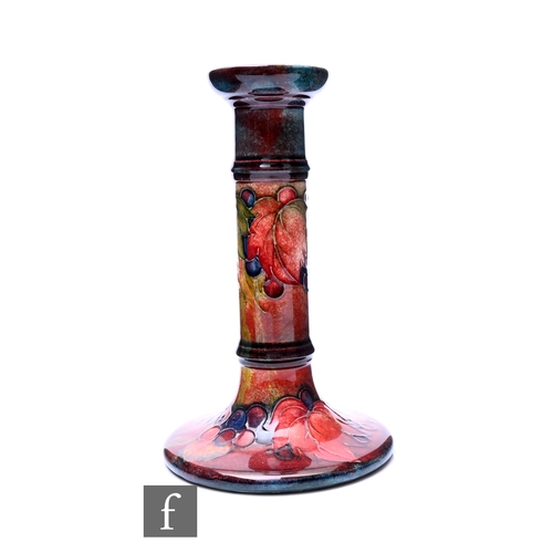 241 - William Moorcroft - Moorcroft Pottery - A flambe Leaf and Berry candlestick, tube line decorated wit... 